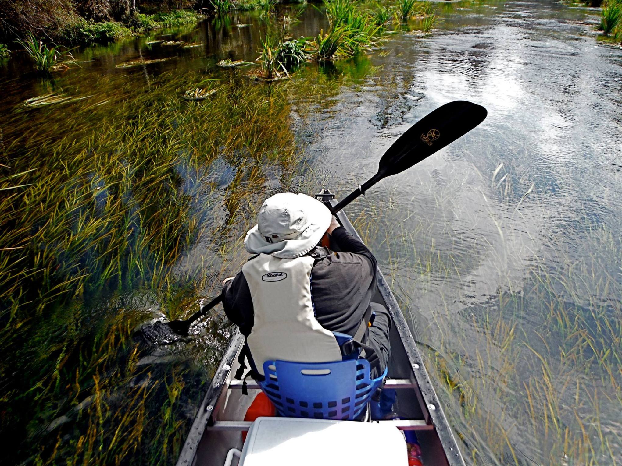a man riding on the back of a boat in a body of water